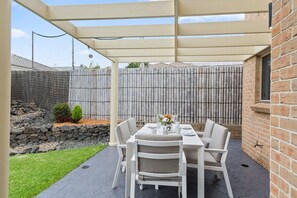 The patio offers a six-seater outdoor setting for relaxed alfresco dining.
