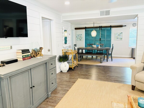 Living room has a Roku smart TV with cable, sectional sofa, and lounge chair.