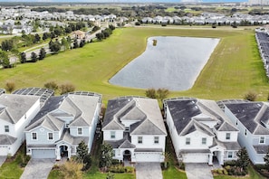 Aerial view shows the home's privacy—no rear neighbors and a peaceful pond backdrop.