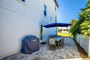 Private backyard with dining table and grill