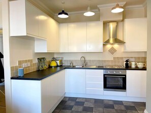 Fully equipped kitchen with oven and hob, grill, microwave, fridge, coffee maker and washing machine