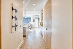 To the right, you'll find a neat closet housing a washer and dryer, while a well-appointed kitchen awaits on the left. The space is graced with beautiful, ambient lighting.