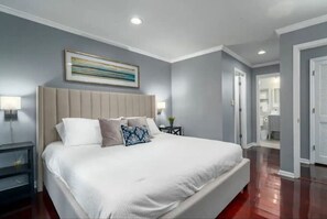 Master bedroom with king bed and flat-screen TV, featuring an ensuite master bathroom.