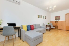 A spacious living room with a gray corner sofa, a wooden table, and modern decor.