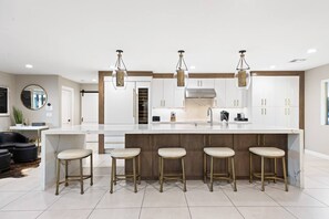 Experience our culinary heaven with this stunning kitchen featuring a spacious center island complete with cozy stools.