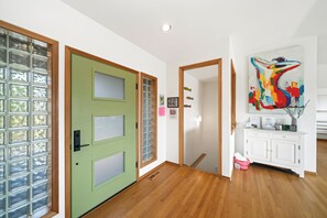 Entrance to first floor with 3 bedrooms, kitchen, dining, living area, and access to outdoor space and garage.