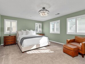 Cozy queen bed with comfy chair and foot rest