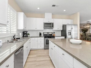 White, wooden cabinetry with stainless steel appliances