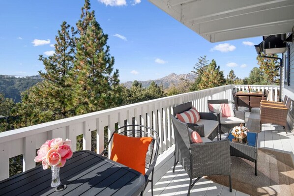 An amazing patio right off of the main living area with expansive views, an outdoor dining table for 6, lounge area, and BBQ!