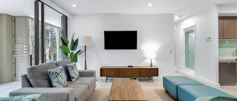 The breezy living area is set with two comfortable lounges fronting a smart TV.