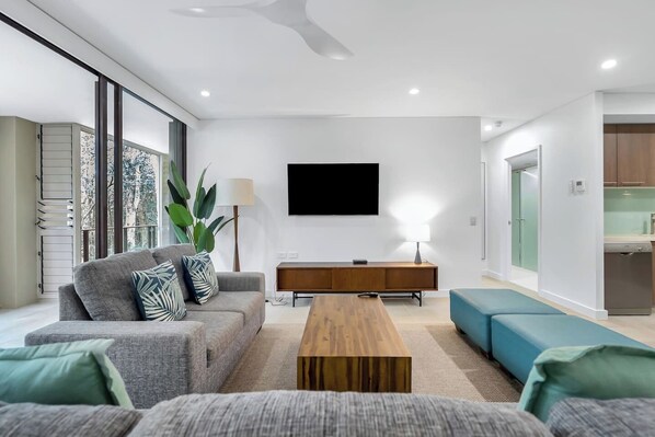 The breezy living area is set with two comfortable lounges fronting a smart TV.  