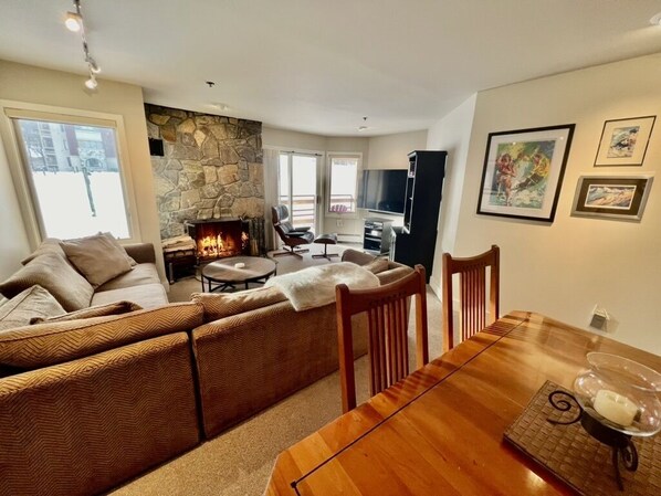 Living Room with fireplace and 65" TV. Direct mountain and lift views.