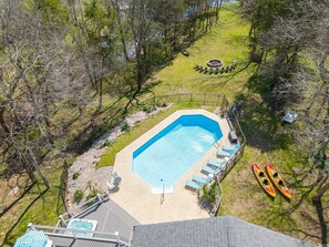 Aerial shot of the pool showing lounge chairs. Rental comes with 2 kayaks plus 1 each 2+ person Canoe. Huge fire pit has resin Adirondack chairs for evening bonfires. Split wood is included. 