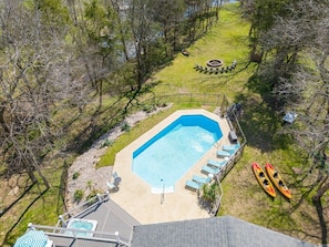 Aerial shot of the pool showing lounge chairs. Rental comes with 2 kayaks plus 1 each 2+ person Canoe. Huge fire pit has resin Adirondack chairs for evening bonfires. Split wood is included. 