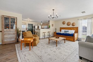 Walk into the warm and welcoming living room and combined sleeping area of The Ranch House.