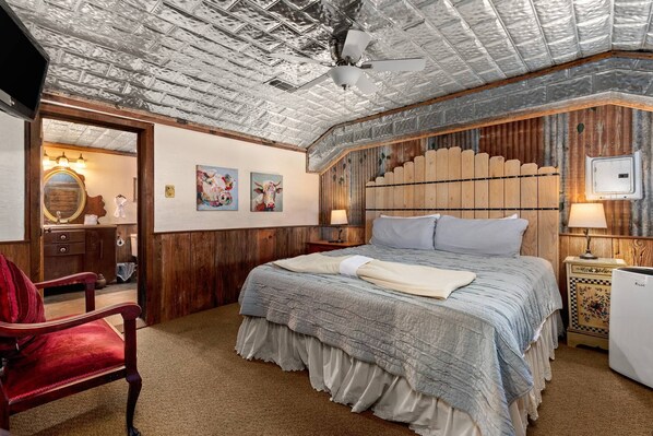 The combination of the open layout (no private door), regal king bed, and the distinctive tin-paneled ceiling makes this bedroom a haven of comfort.