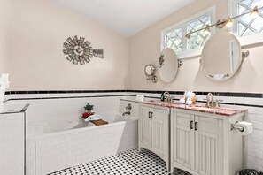 This elegant black and white tiles bathroom is adorned with dual vanities, offering both style and functionality.