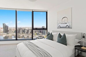 The master bedroom with a queen sized bed & plush pillows.
