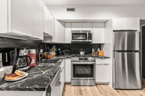 This photo highlights the modern and functional design of the kitchen. The sleek countertops and stainless steel appliances make this space a joy to cook in, with everything you need at your fingertips.