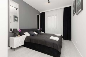 A stylish bedroom with a black-and-white theme, a large bed, and minimalist decorations.