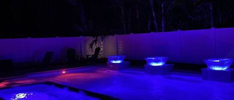 Pool at night with water fountains on