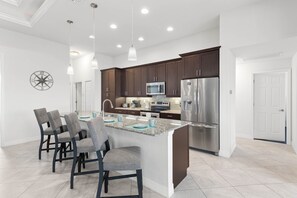 Modern Kitchen - - Cook in this sleek kitchen with stainless steel appliances and granite countertops
- Spacious island with seating makes it perfect for casual meals or entertaining
- Bright lighting and clean design create an inviting space to gather and enjoy