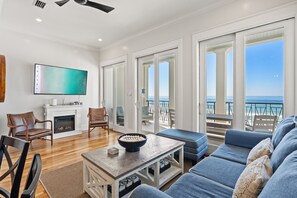 Living Room with comfortable seating, Gulf views, electric fireplace, and 55” Smart TV