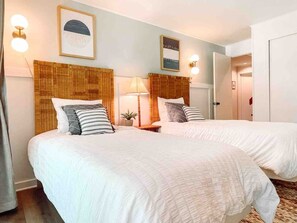 This bright and airy bedroom has two twin beds that can be converted into a king with advance notice. Two desks, a TV, and direct access to the first floor patio lounge give this room everything you need.