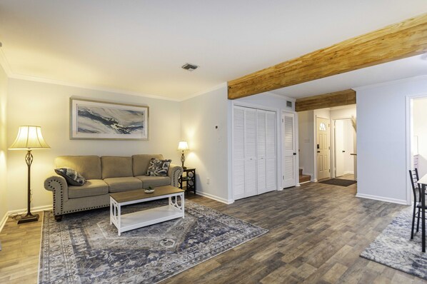 Spacious living area with comfortable sofas, books and a TV to relax and unwind.