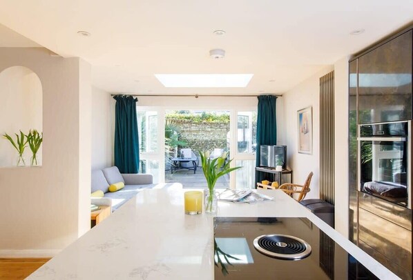 The downstairs has an open plan kitchen and living space, perfect to prepare food and drink, and unwind after a day exploring the city.