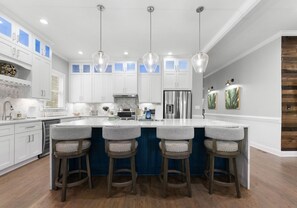 Open space kitchen with new, stainless, appliances.