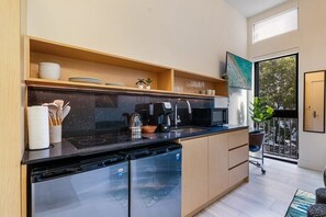 Fully equipped kitchen with two mini fridges, workstation with office chair, and 55" smart tv