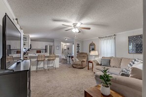 Welcome to our cozy home featuring an open-layout living space with comfy seating and a well-equipped kitchen - perfect for relaxation or entertaining.