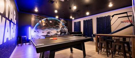 Immerse yourself in a Star Wars adventure with this themed game room featuring ping pong and basketball arcade games.