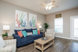 Living space on the second floor with queen size sleeper sofa and access to the private balcony