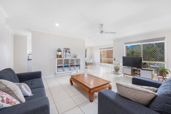 The spacious living room boasts two sofas, providing a space for relaxation or entertainment. Ample natural light and a TV enhance the atmosphere for your favourite shows.