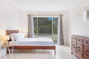 The first bedroom is furnished with a queen bed, creating a restful atmosphere. Utilise the dresser to store your belongings conveniently.