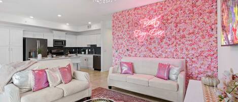 A studio like design of the living area with a floral background wallpaper fronting the private balcony
