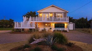 Lil'TipSea at Twilight. The property entrance door is downstairs, inside the gate, on the side of the house where the swing is located. The door has glass windows and your code will only work on this door. The car garage door was replaced with siding.