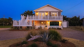 Lil'TipSea at Twilight. The property entrance door is downstairs, inside the gate, on the side of the house where the swing is located. The door has glass windows and your code will only work on this door. The car garage door was replaced with siding.