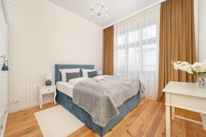 A cozy bedroom with a large bed, soft lighting, and neutral decor.