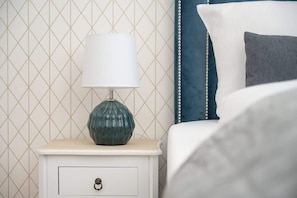 A close-up of the bed with decorative pillows and a bedside table.