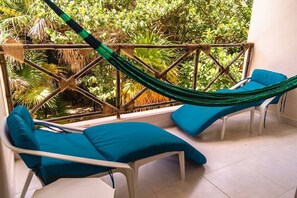 The terrace opens over the patio covered in tropical trees