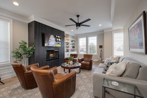 2nd Floor: Bright open-concept living area with comfortable seating, fireplace, and smart TV.