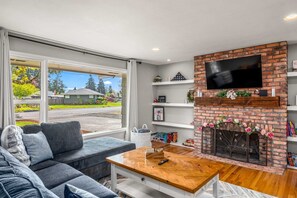 Open living room, large picture window. Decor rotated seasonally. Remote candles
