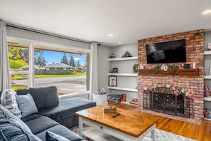 Open living room, large picture window. Decor rotated seasonally. Remote candles