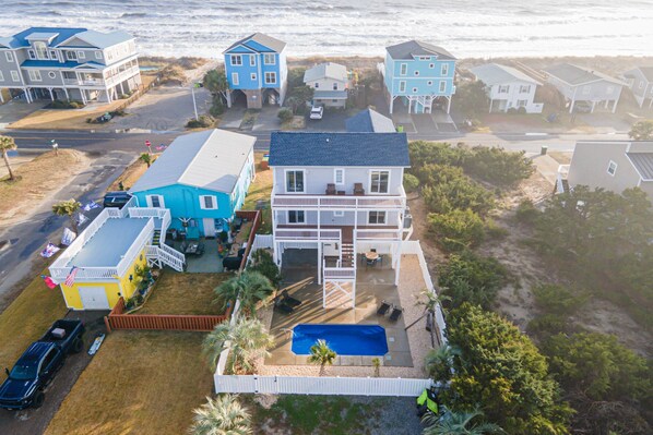 From the back, you see the beach access across the street, the enclosed backyard pool & 2 decks with 180° views of the marsh side.