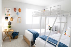 Discover the charm of the kids room! A full bed with a 250 lb. weight limit over 2 cozy twin bunk beds, all boasting comfy memory foam mattresses and adorable bedding. Perfect for a group of 4 little adventurers. 