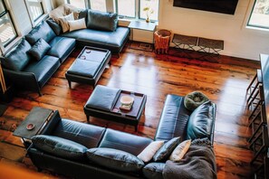 Main level great room is surrounded by large windows letting nature in at every angle. Ceilings soar open to the second floor, providing a dramatic, yet cozy space. *Electric fireplace will reinstalled by mid-December. 