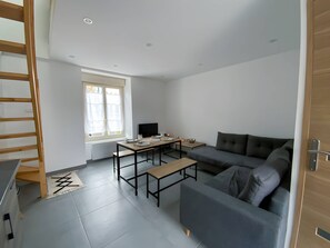 "Modern Living Room: Corner Sofa, TV, Window, Dining Table"